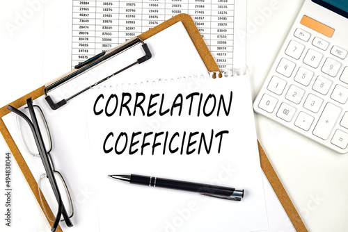 Fototapeta kuchenna Text CORRELATION COEFFICIENT on the white paper on clipboard with chart and calculator
