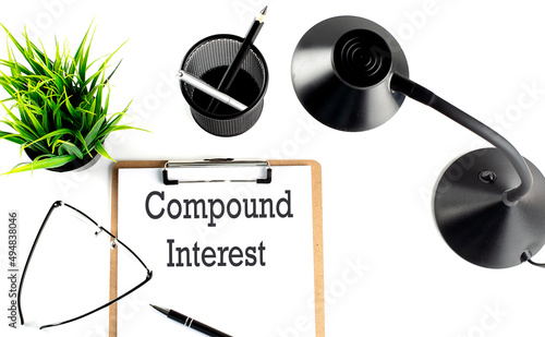 COMPOUND INTEREST text on a clipboard on the white background