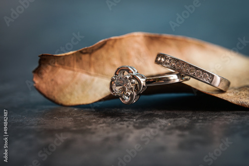 Closeup of a diamond engagement ring placed on a leaf. Love and wedding concept. 