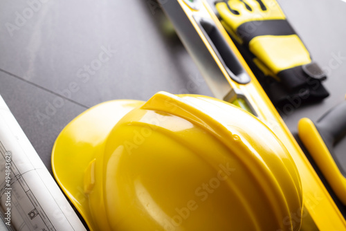 Wallpaper Mural Business contraction theme. Tool kit of the contractor: yellow hardhat, libella, hand saw. Plans and notebook on the gray tiles. Torontodigital.ca