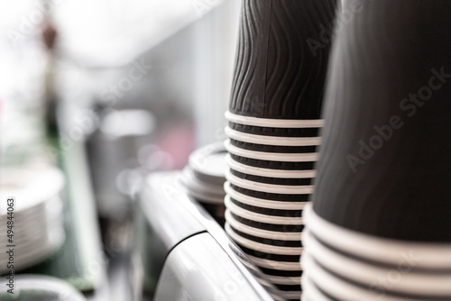 Close-up of lot of drinking paper coffee cups in coffee shop. Copy space, selective focus