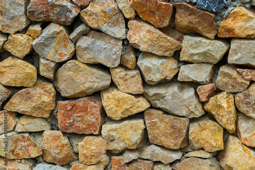 yellow stone fence. Stone masonry from large cobblestones of granite. Natural texture and background  backdrop