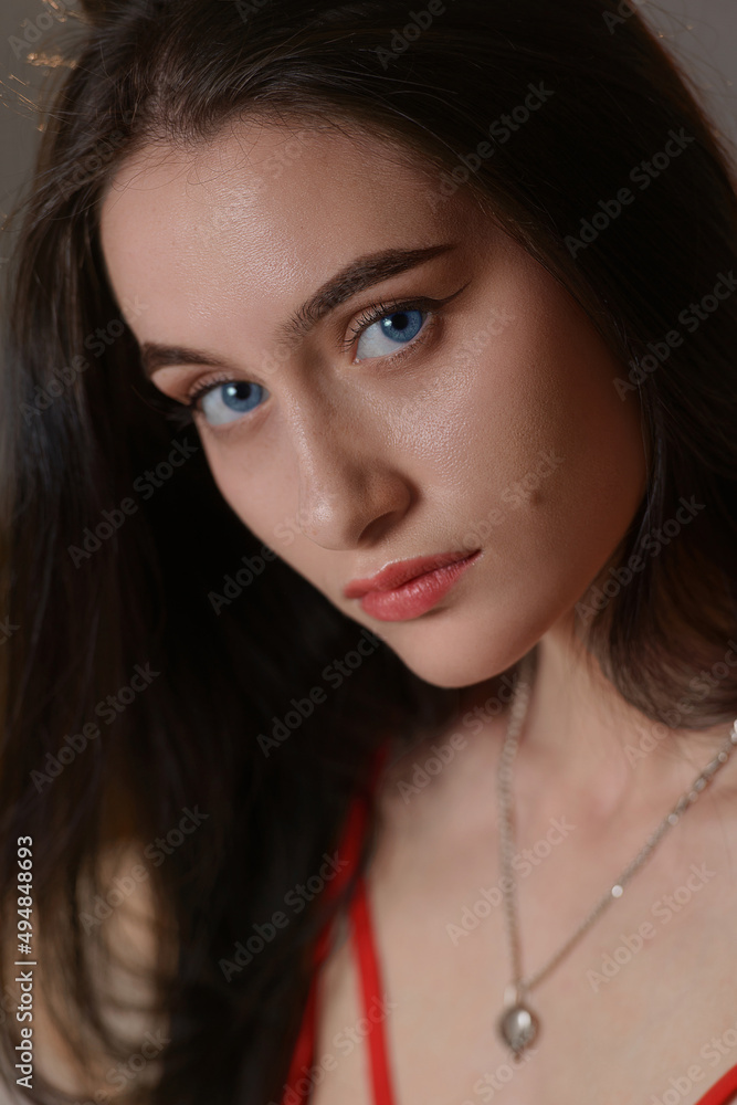 Close-up portrait of a young brunette woman in red