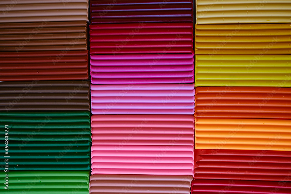 Multi-colored pieces of plasticine are arranged as a background. The concept of educational games for children. Colored background multicolored structure. Plasticine background Multi-colored pieces of plasticine are arranged as a background. The concept of educational games for children. Colored background multicolored structure. Plasticine background