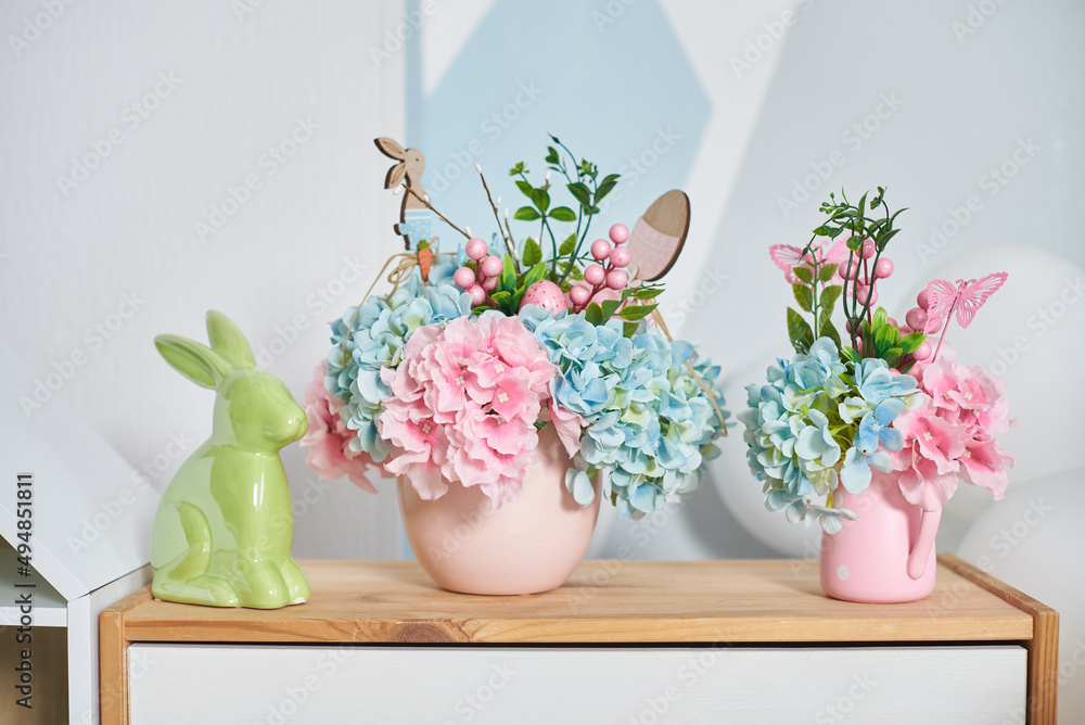 Easter decor with a hare and flowers on a wooden shelf in the interior