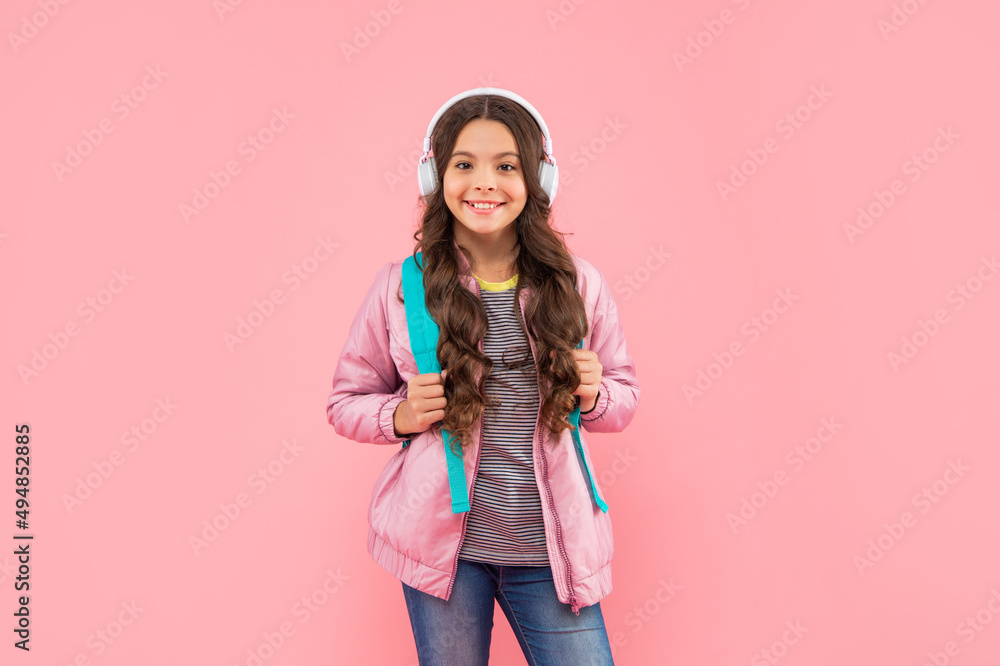 happy teen girl with backpack wearing headphones on pink background, school happy teen girl with backpack wearing headphones on pink background, school