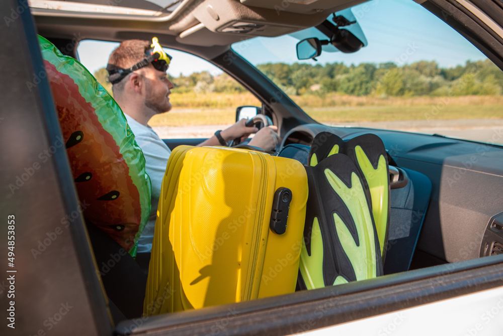 Naklejka premium sea vacation car travel concept man in scuba mask driving car full of bags