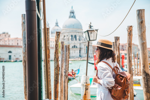 woman in white clothes with straw hat at pier basilica santa maria della salute on background