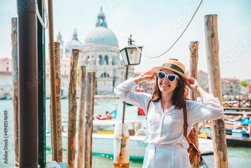 woman in white clothes with straw hat at pier basilica santa maria della salute on background