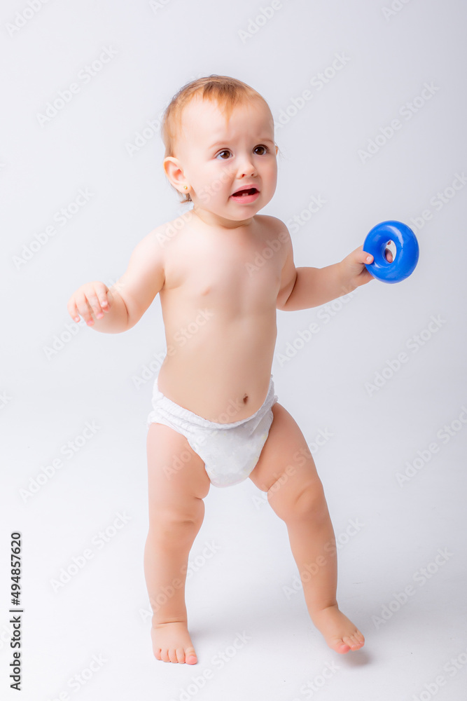 cute baby girl in a diaper stands in full height isolated on a white background cute baby girl in a diaper stands in full height isolated on a white background