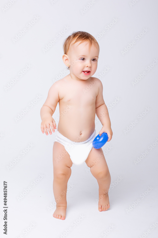 cute baby girl in a diaper stands in full height isolated on a white background cute baby girl in a diaper stands in full height isolated on a white background