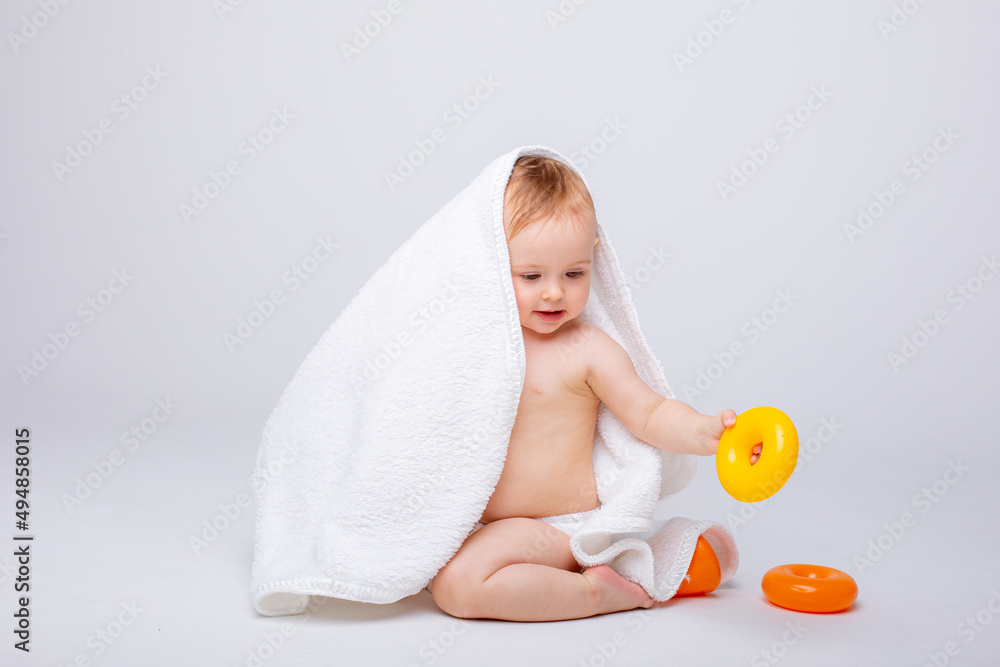 cute baby girl in a diaper playing with a pyramid colored toy isolated on a white background cute baby girl in a diaper playing with a pyramid colored toy isolated on a white background