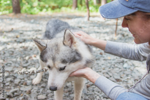 Young woman with her husky dog outside in the yard.