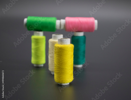 color yarn on spool, yarn on tube, cotton, wool, linen thread, isolate on black background