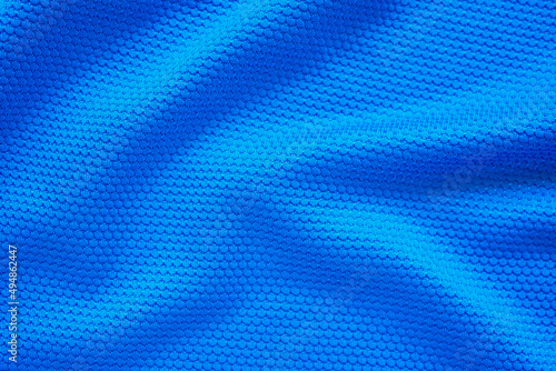 Blue football jersey clothing fabric texture sports wear background, close up top view © Piman Khrutmuang