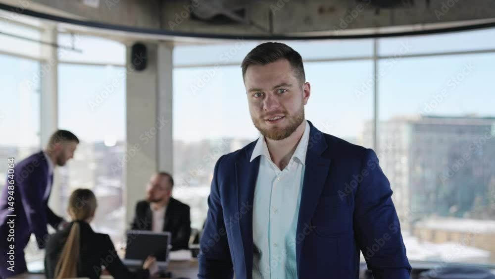 Handsome adult young businessman in dark blue jacket looking straight at camera. Portrait of a modern business owner. Team communicating at backdrop. Handsome adult young businessman in dark blue jacket looking straight at camera. Portrait of a modern business owner. Team communicating at backdrop.