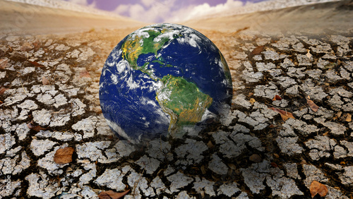 The globe disappears into the cracked barren land as the effects of global warming and extreme climate change. water soil environment concept.