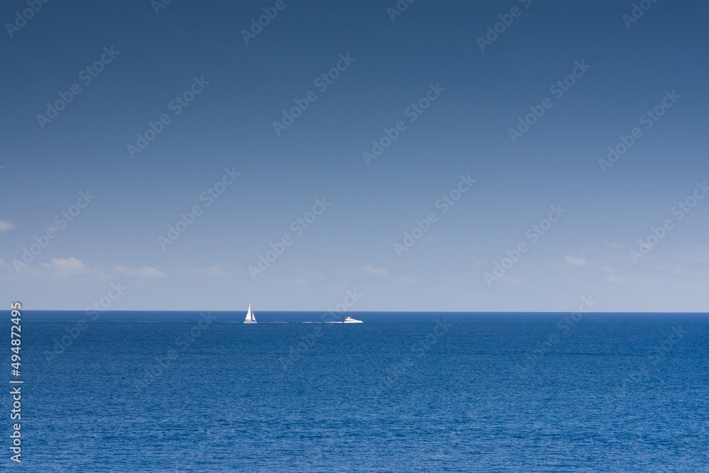 Yacht on the horizon, blue sea and sky. Minimalist film, simplicity, positivity.