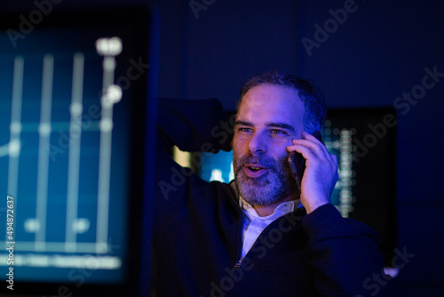 Successful stockbroker trading late at night on phonecall photo