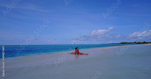 Couple laying on the sandy beach of the Rasdhoo island of the Maldives photo