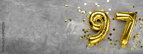 Yellow foil balloon number, number ninety-seven on a concrete background. Greeting card with the inscription 97. Anniversary concept. for anniversary, birthday, new year celebration. banner,