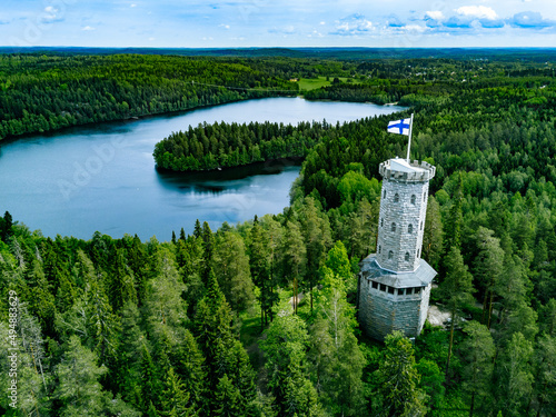 Aerial view of observation tower with Finnish flag among blue lakes and green forests in summer Finland. photo