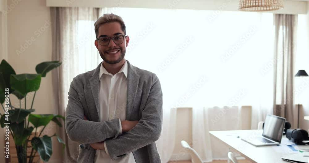 Young man smiling on camera inside modern office Young man smiling on camera inside modern office