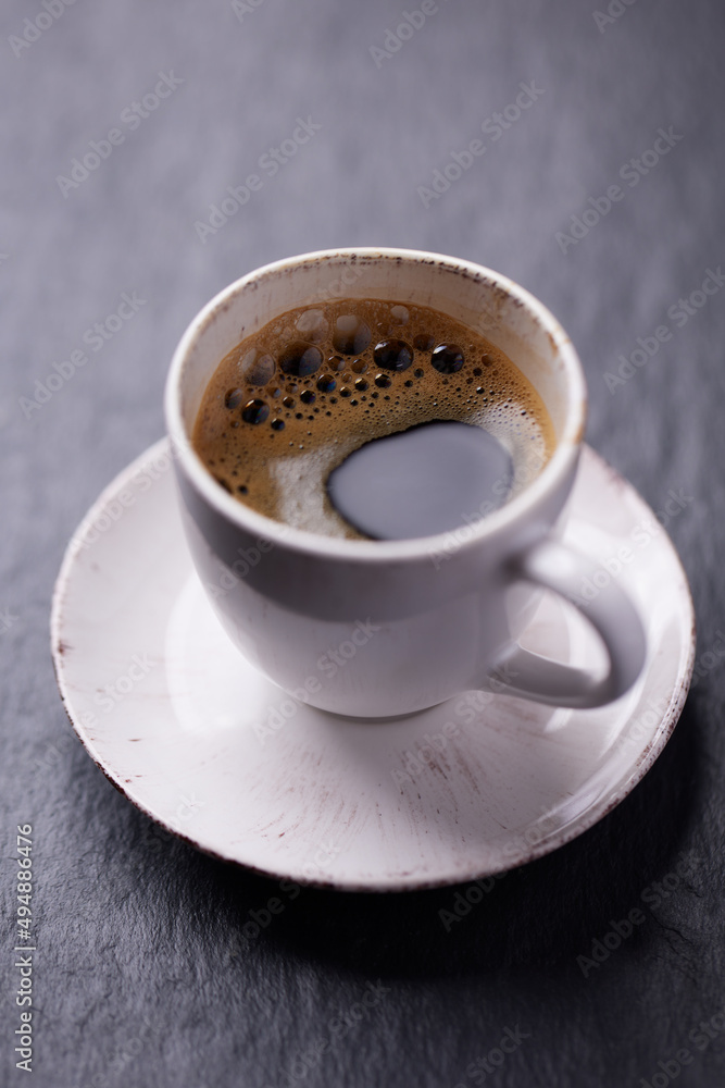 Cup of coffee on dark stone background. Close up. Cup of coffee on dark stone background. Close up.