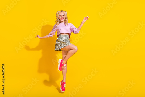 Full body portrait of excited overjoyed girl jump enjoy summer holiday isolated on yellow color background