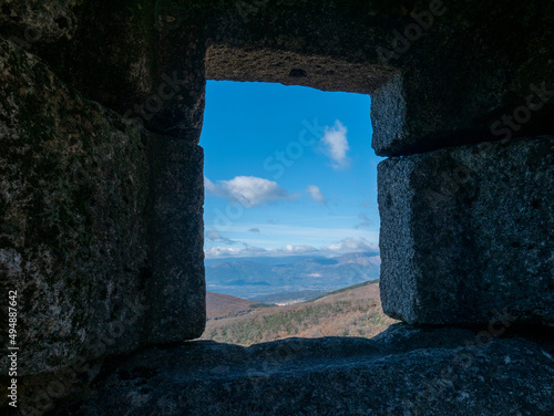 Beautiful view of the nature from a stone window of a ruin photo