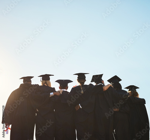 We are ready for whatever comes next. Rearview shot of a group of university students standing outside on graduation day.