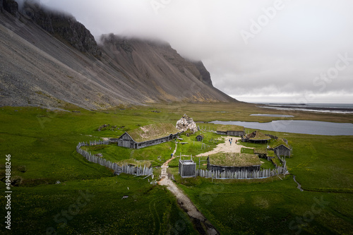 Photos Scenic view of a viking village in Iceland surrounded by rocky hills on cloudy w