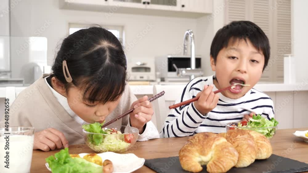 自宅で朝食をサラダを食べるアジア人の子供