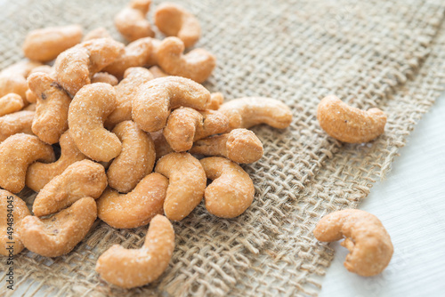 Salted cashew nuts on sackcloth background.