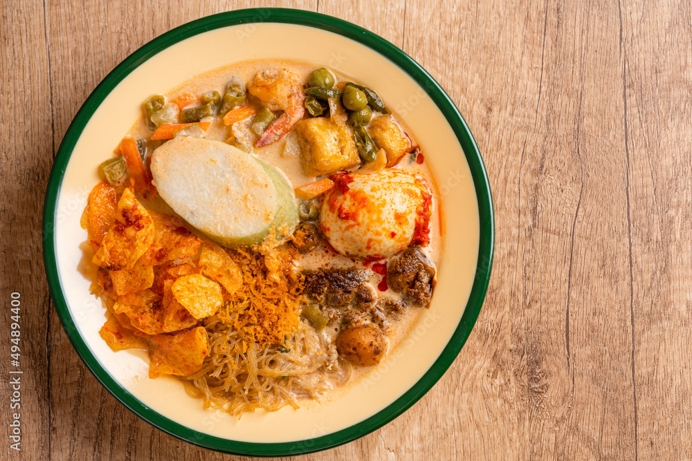 Lontong sayur or vegetable rice cake is an Indonesian traditional rice dish made of pieces of lontong served in coconut milk soup with shredded chayote, tempeh, tofu, hard-boiled egg, sambal, rendang Lontong sayur or vegetable rice cake is an Indonesian traditional rice dish made of pieces of lontong served in coconut milk soup with shredded chayote, tempeh, tofu, hard-boiled egg, sambal, rendang