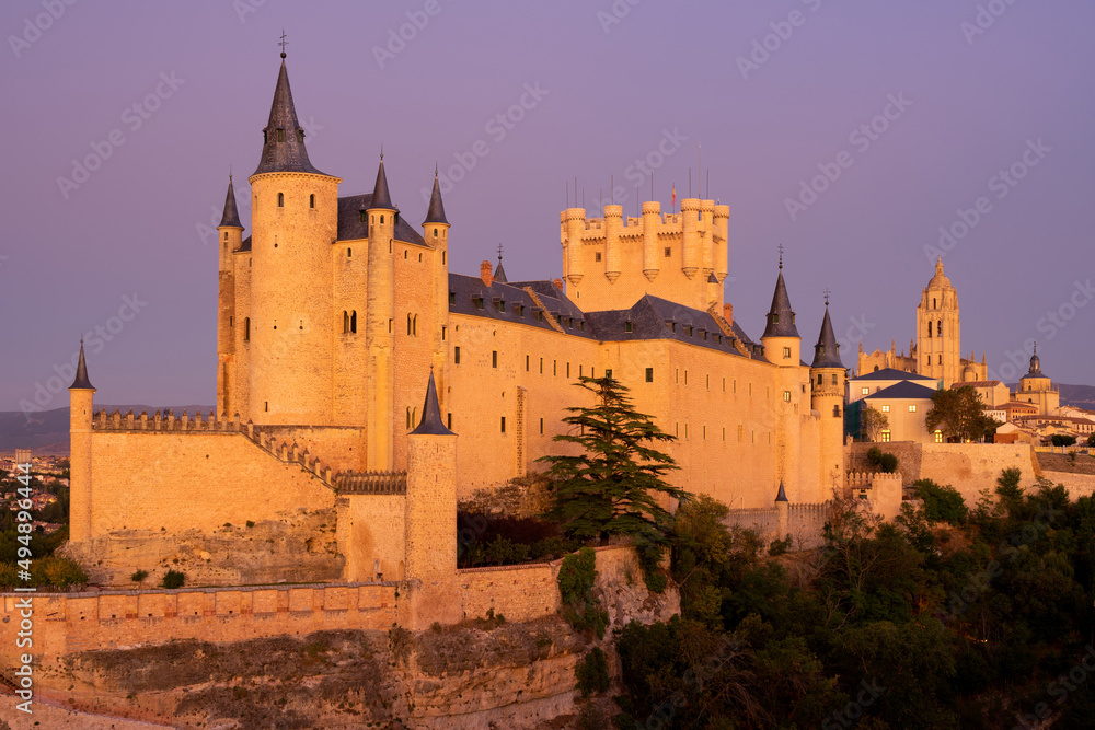 View of the Alcazar fortress and St Mary cathedral of segovia with alpenglow in the background, listed world Heritage centre by UNESCO