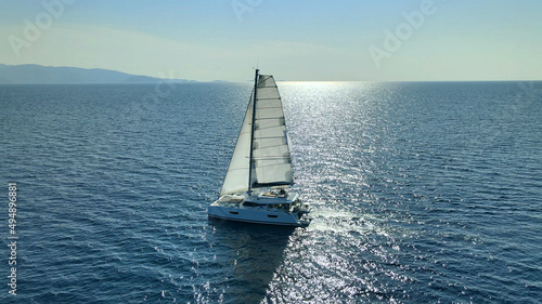 Fotografie Catamaran Yacht Under Sail Moving On Open Sea At Sunset
