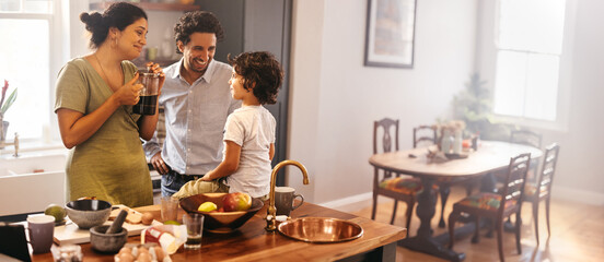 Ethnic parents spending time with their son in the kitchen