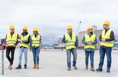 Team of industrial engineers working in logistic terminal of container cargo
