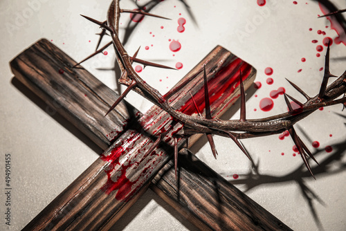 Crown of thorns, wooden cross and blood drops on light background. Jesus Christ's sacrifice and atonement of our sins