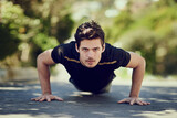 Getting stonger. Full length portrait of a handsome young man doing pushups outdoors.