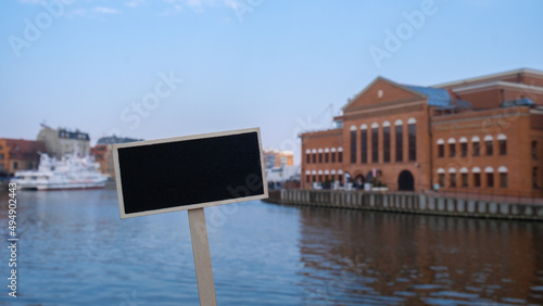 Empty mockup template Blackboard label against Polish Baltic F. Chopin Philharmonic in Gdansk is a concert hall located on Olowianka island on the Motlawa river. Baltycka Philharmonic in Gdansk photo