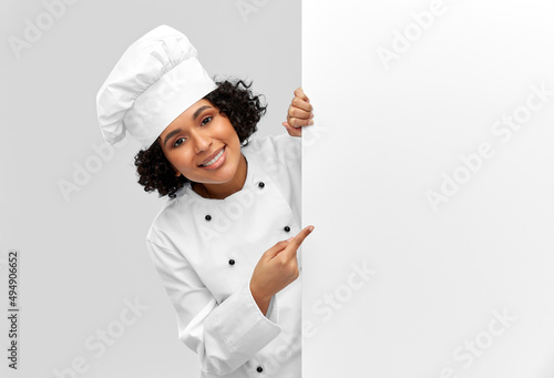 cooking, advertisement and people concept - happy smiling female chef in toque with white board over grey background