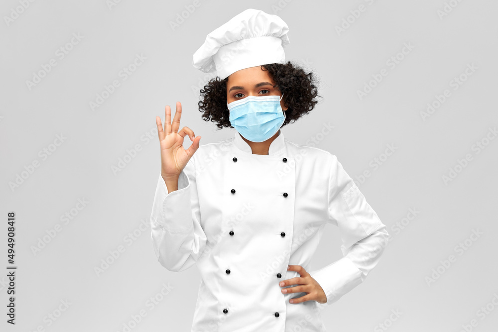 cooking, pandemic and health concept - happy smiling female chef in protective medical mask over grey background cooking, pandemic and health concept - happy smiling female chef in protective medical mask over grey background