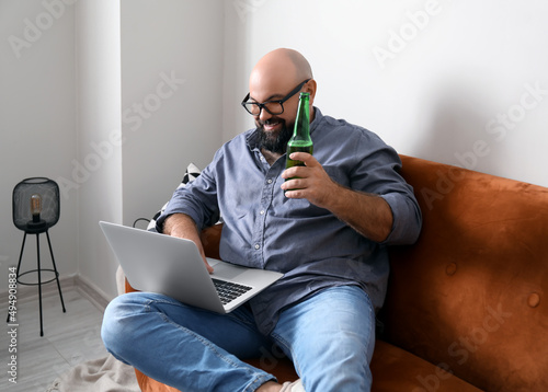 Man with laptop drinking be...