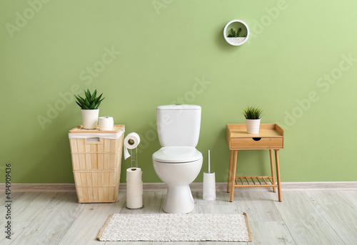 Interior of stylish restroom with toilet bowl and paper rolls photo