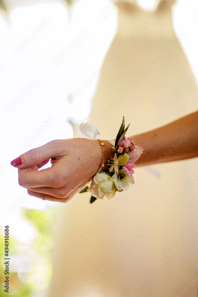 bracelet de fleurs blanches et roses porté à l'occasion d'un mariage  - obrazy, fototapety, plakaty 