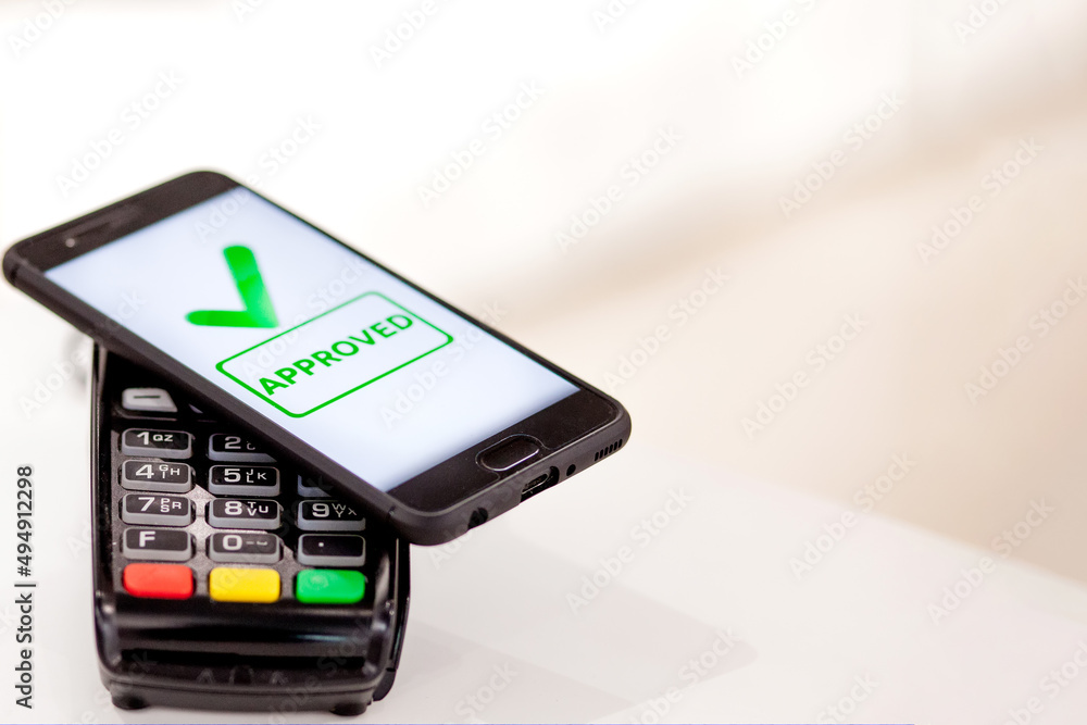 POS terminal, Payment Machine with mobile phone on store background. Contactless payment with NFC technology POS terminal, Payment Machine with mobile phone on store background. Contactless payment with NFC technology