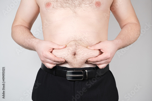 The man shows belly fat. Obesity in men, weight loss photo