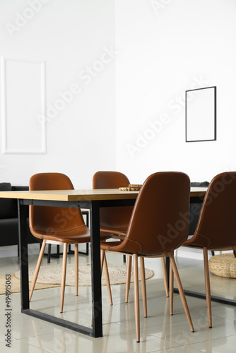 Interior of light dining room with table and modern chairs